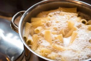 Rigatoni nella pentola di acqua bollente